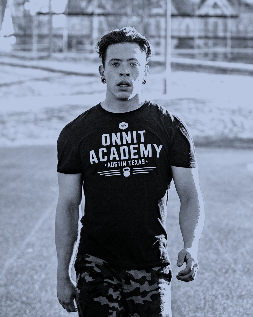Jason Osaj standing on an outdoor track, looking directly at the camera